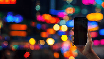 Telephone dans la main sur fond de lumiere coloré 